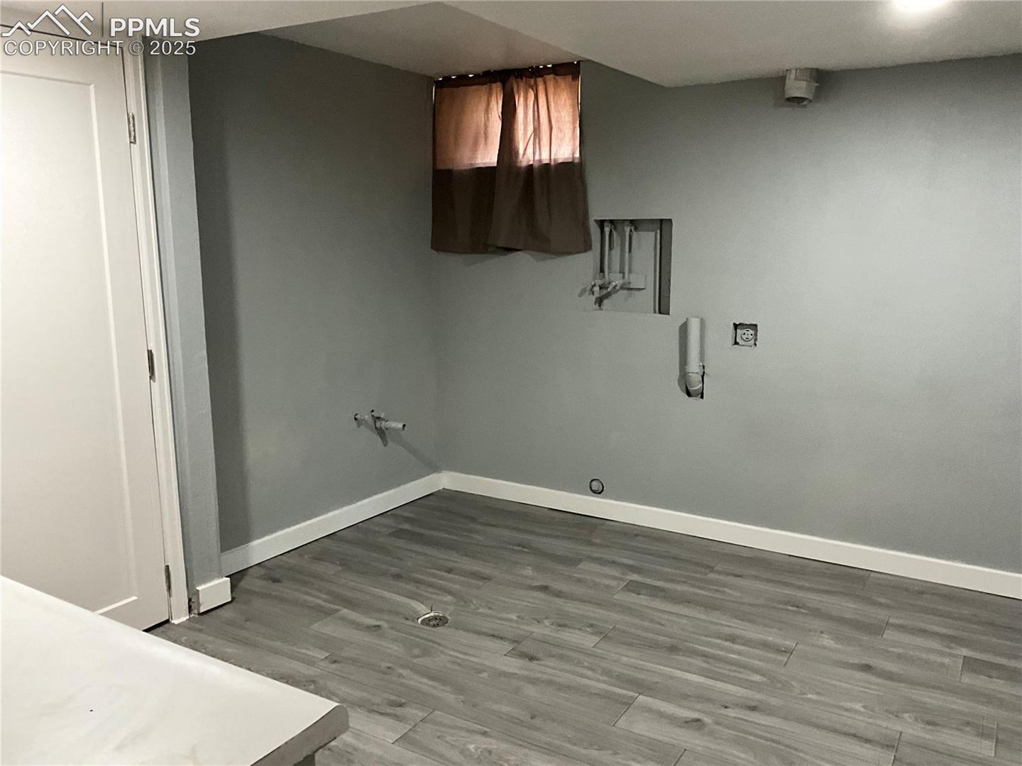 Laundry area featuring light wood-style floors, cabinet space, and hookup for a washing machine