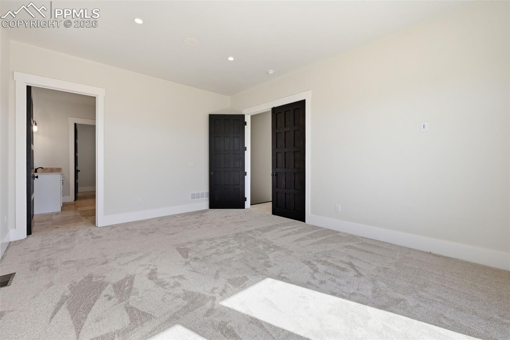 Master Bedroom Suite looking into Bath area and entry from hallway. Note: shadows in foreground are French doors with Romeo & Juliette balacony. 