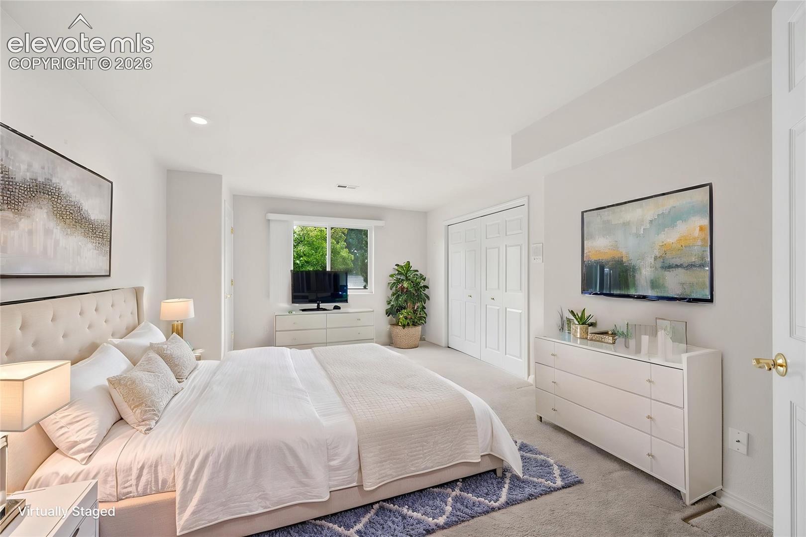 Neutral-toned interior featuring wall-to-wall carpeting, recessed lighting, and a double-door closet