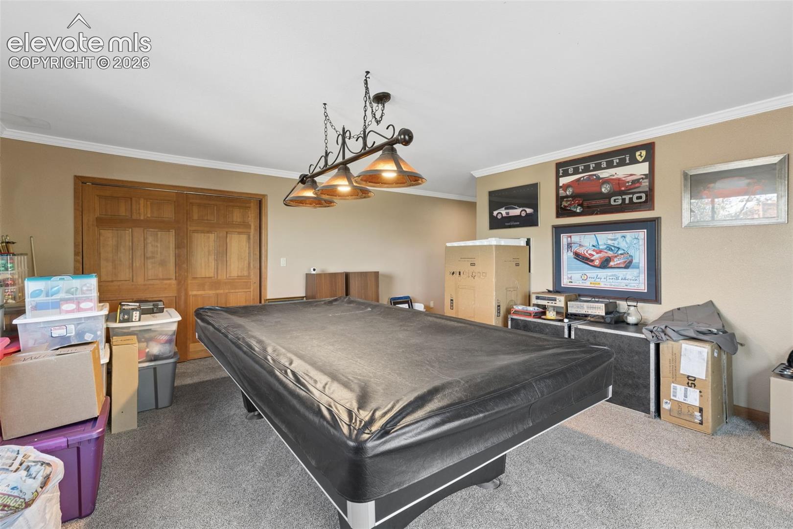 Room featuring neutral-toned walls, ceiling-mounted three-light fixture with bronze-finish accents, and dual-panel wood doors