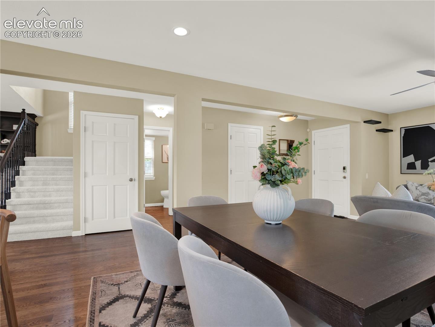 Interior space featuring wood-finish flooring, recessed lighting, carpeted staircase with dark-stained handrail, and six-panel interior doors