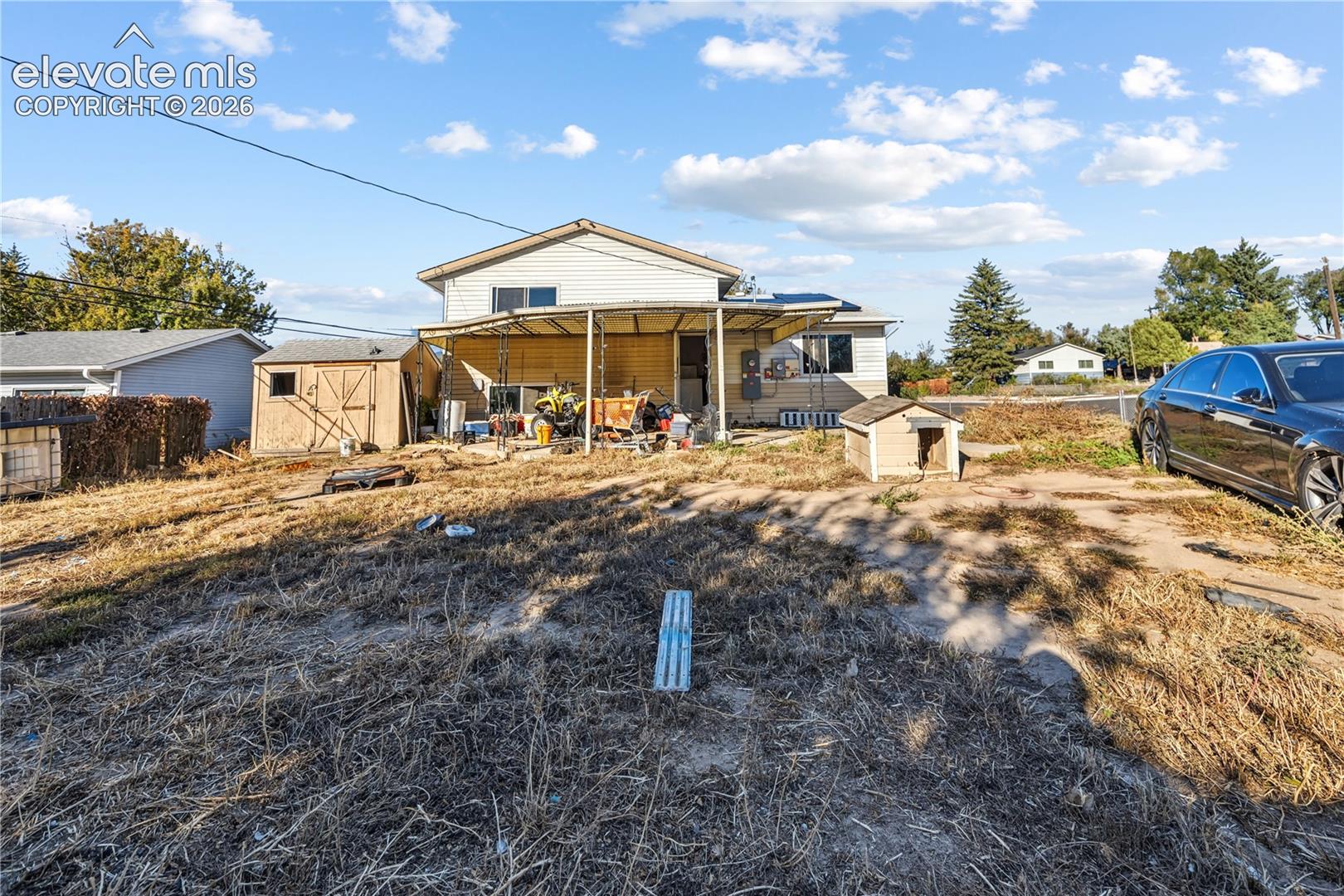 Exterior lot featuring a covered patio, detached storage structure, and horizontal siding