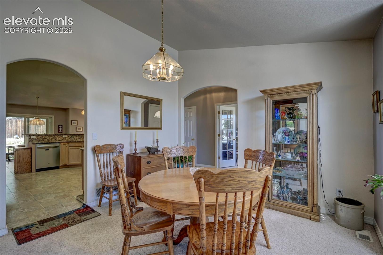 Formal dining room leading to kitchen area.