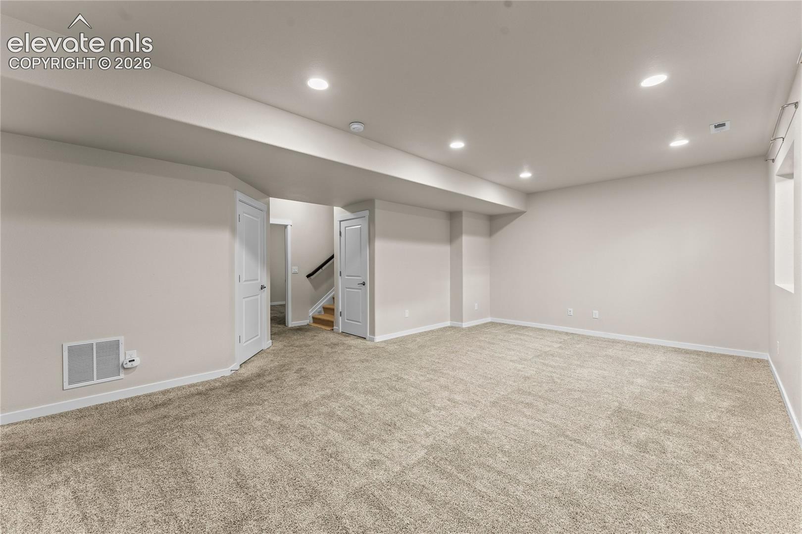 Open-concept interior featuring neutral wall tones, wall-to-wall carpeting, and recessed ceiling lighting