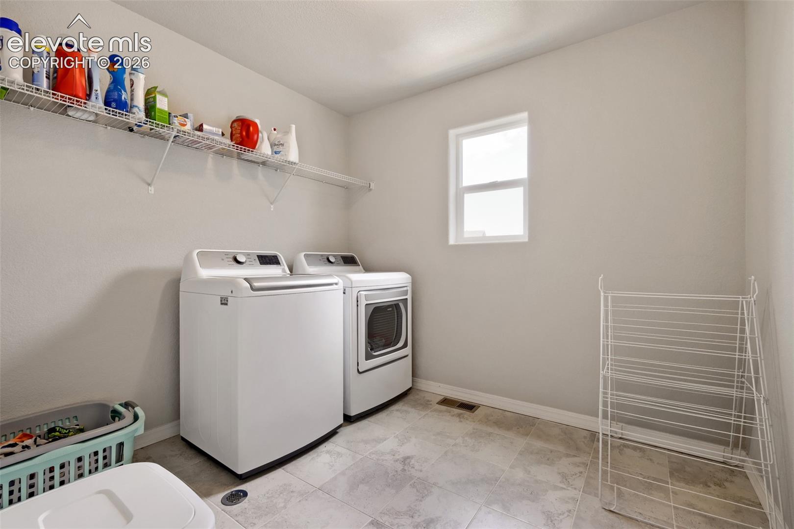 Laundry area with light-toned wall paint and tiled flooring