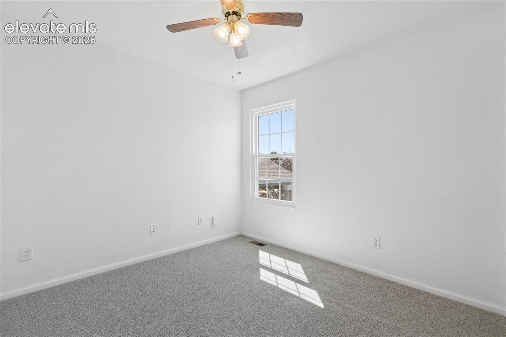 Recessed window with white framing, light gray carpeting, and a ceiling fan with light fixture