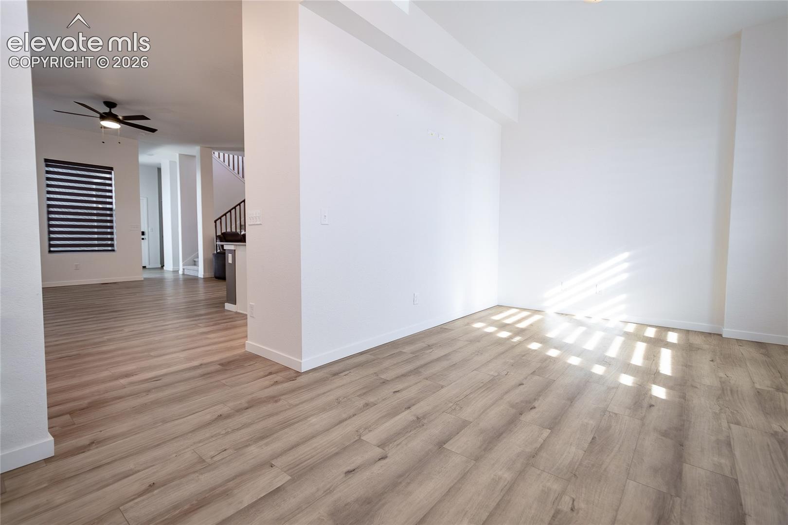 Open interior featuring wood-finish flooring, neutral walls, recessed lighting, and a ceiling fan