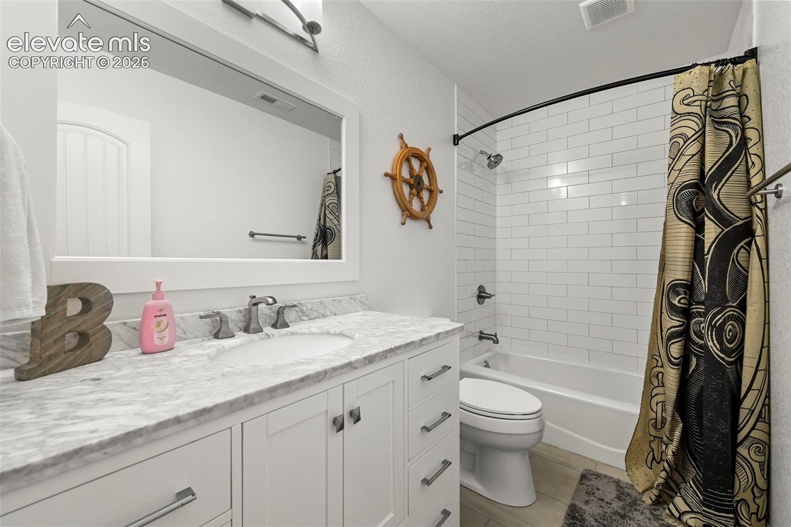 White shaker vanity with a stone countertop and undermount sink
