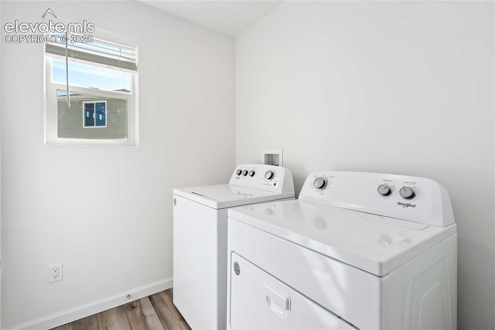 Bright utility space with wood-finish flooring and a window
*photos of a model home*