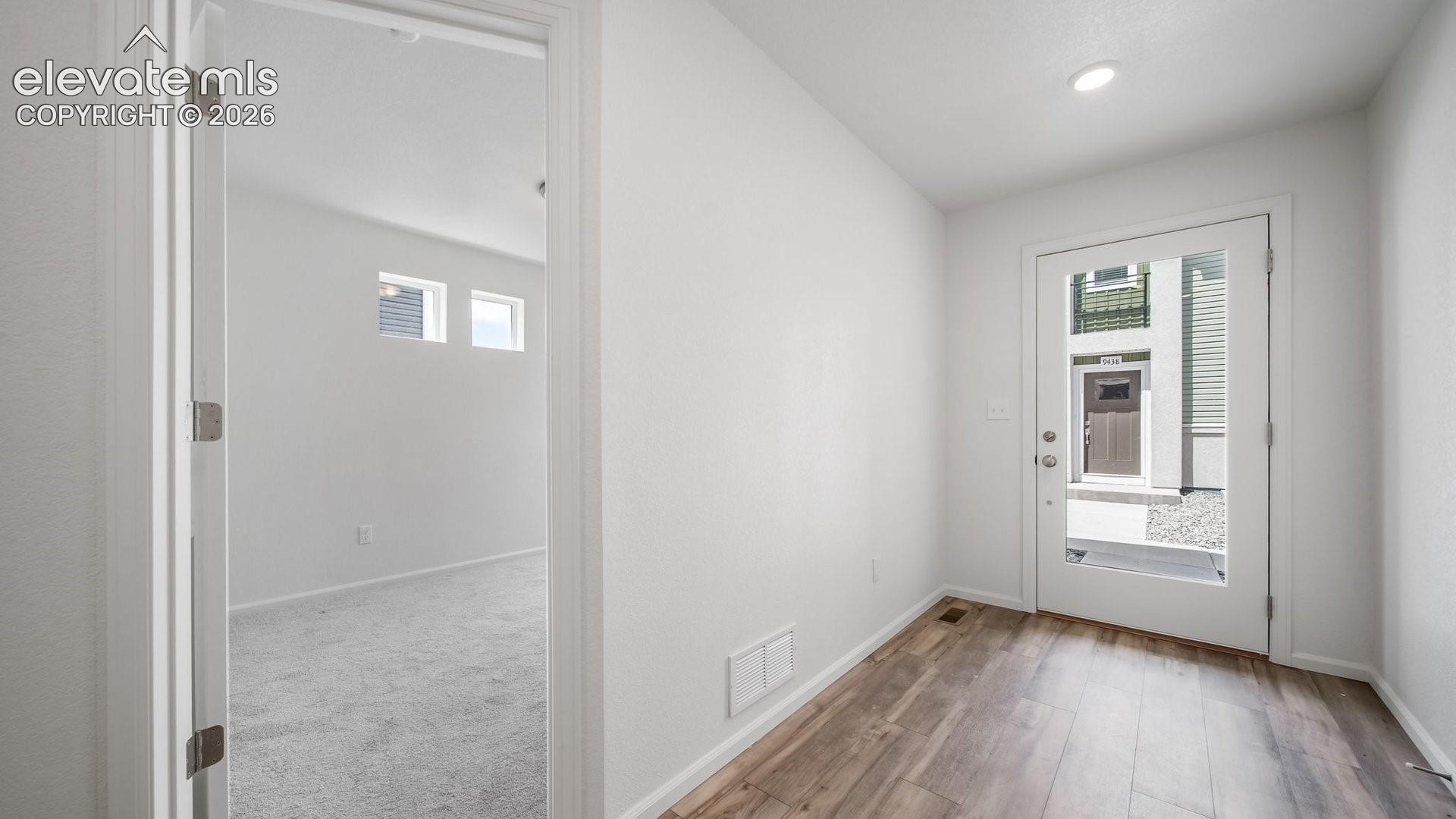 Wood-finish flooring, recessed lighting, and a full-light entry door
*photos of a model home*
