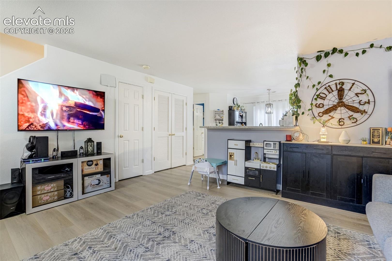 Light-toned wood-finish flooring extends throughout the space