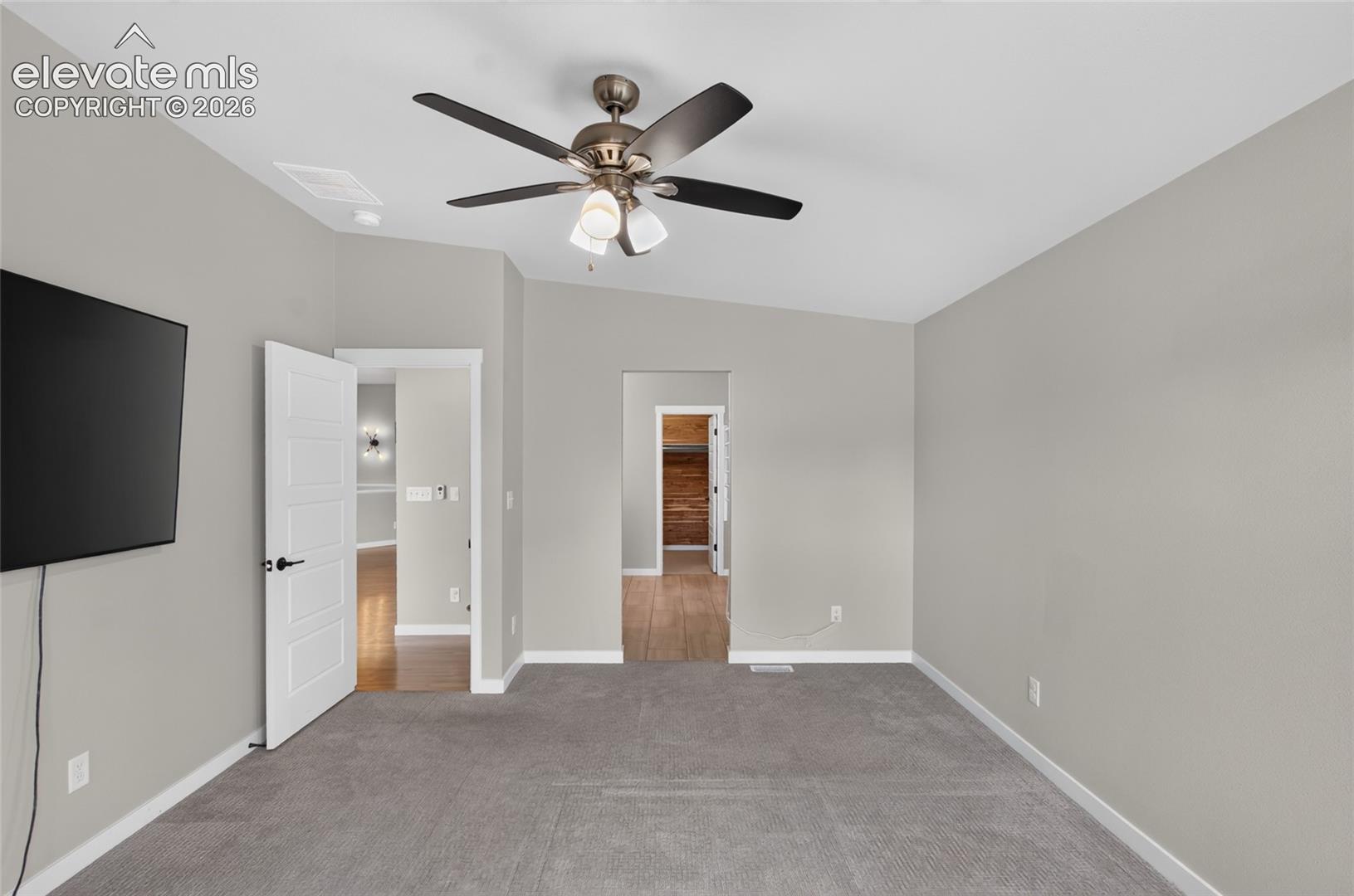 Master Bedroom featuring soft gray wall paint, gray carpet flooring, and a ceiling fan with integrated lighting