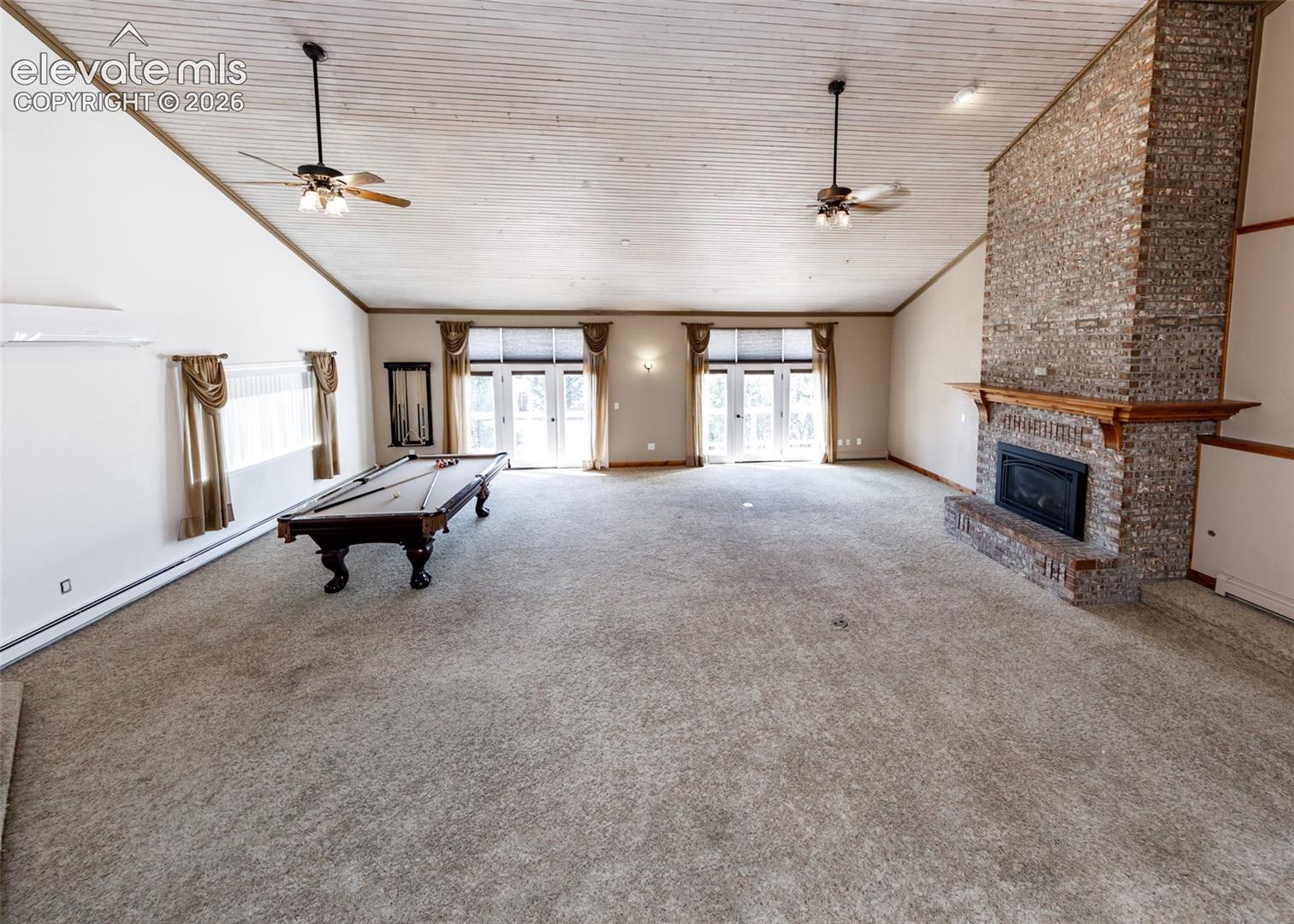 Living room with fireplace and two sliding doors to the upper outside deck