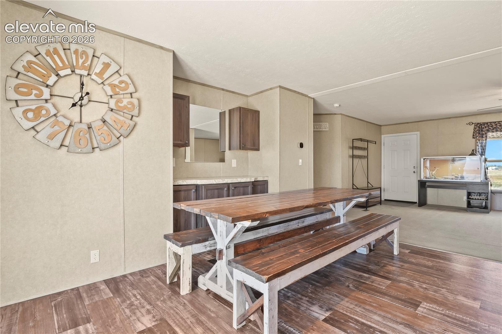 Wood-finish flooring, built-in cabinetry with stone-finish countertops, and an integrated wall-mounted mirror