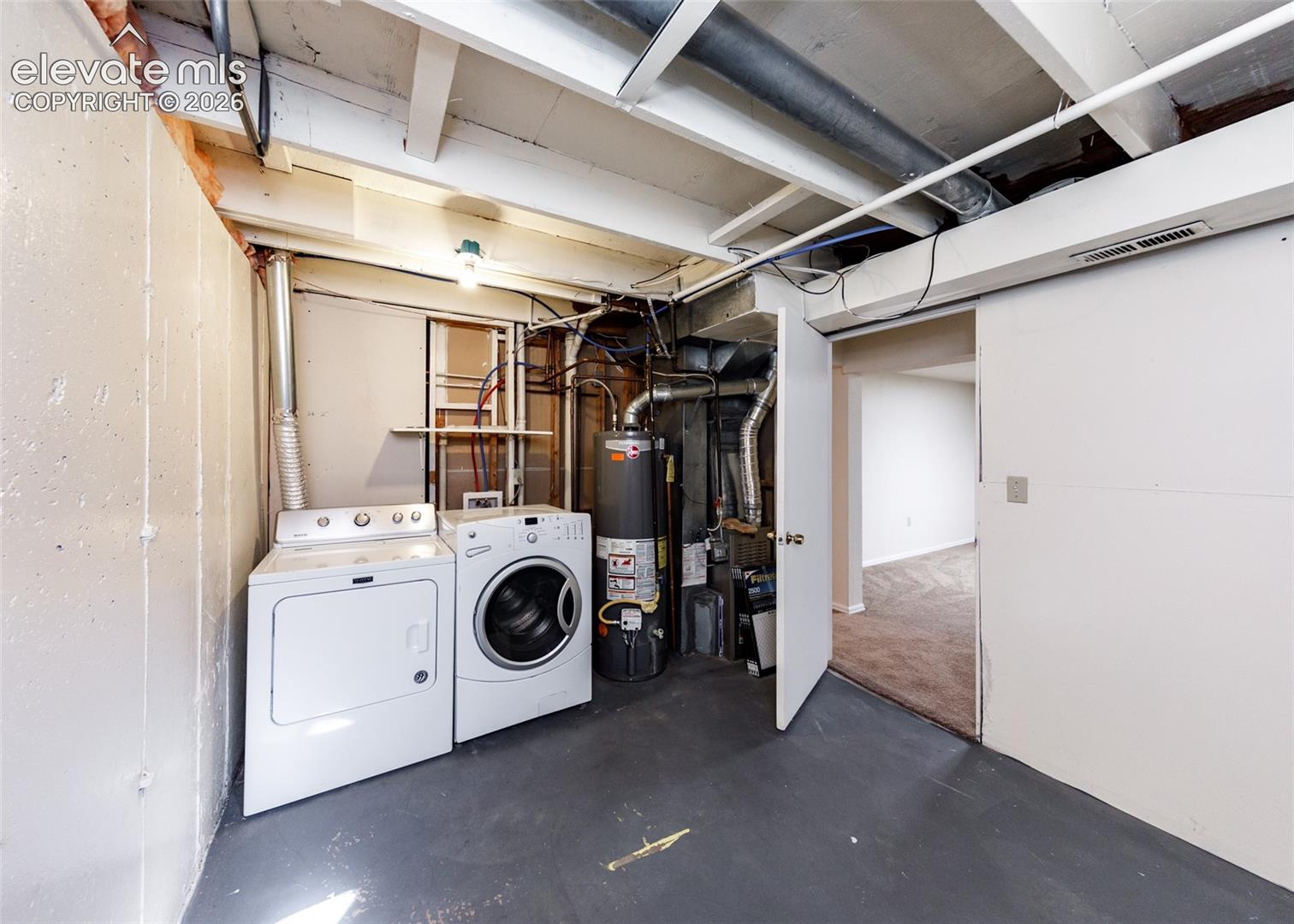 Utility area featuring a dedicated laundry station, water heater, and furnace, finished with concrete flooring and painted walls