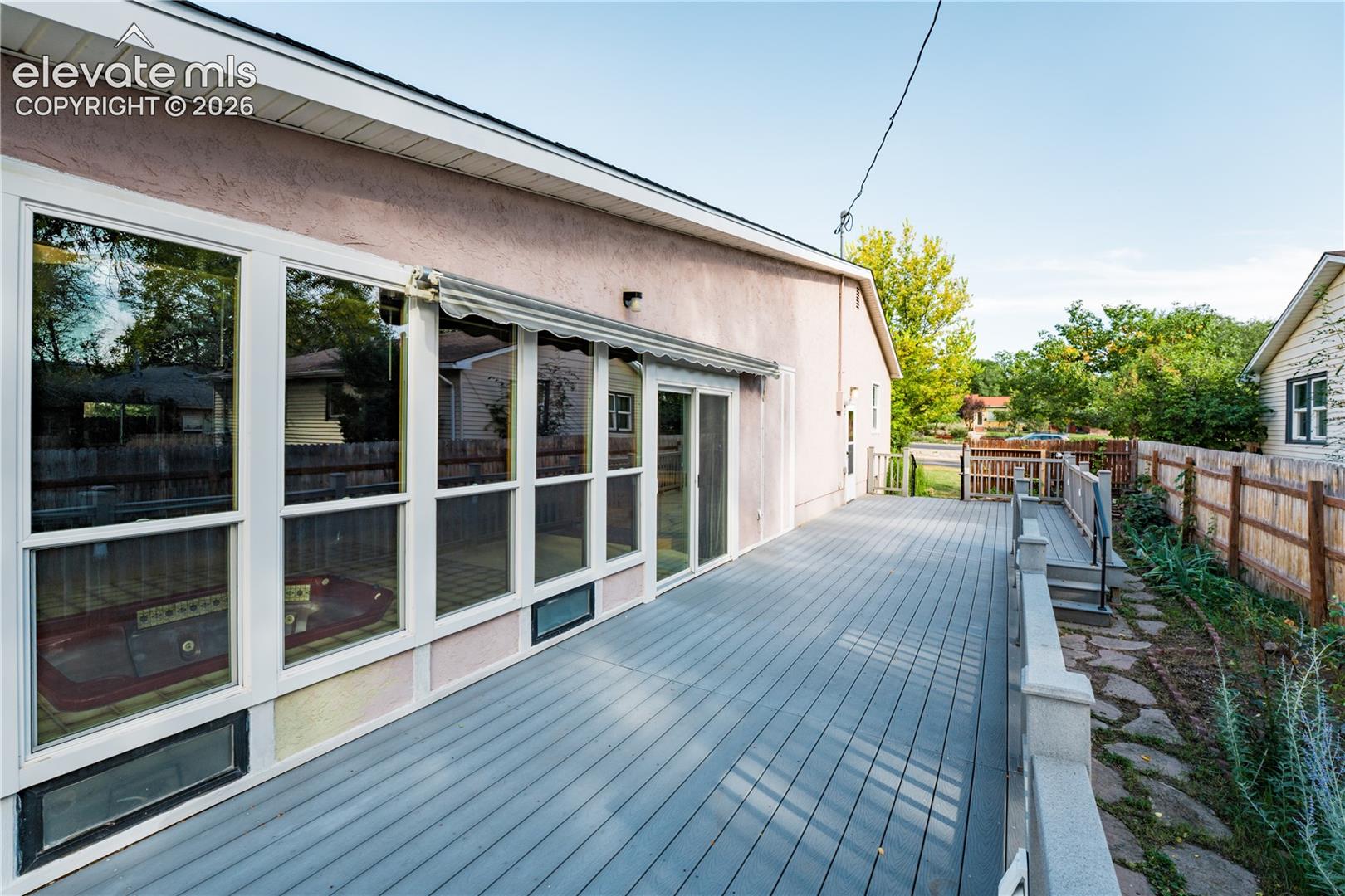 Expansive outdoor deck with gray composite decking, white railings, and a privacy fence