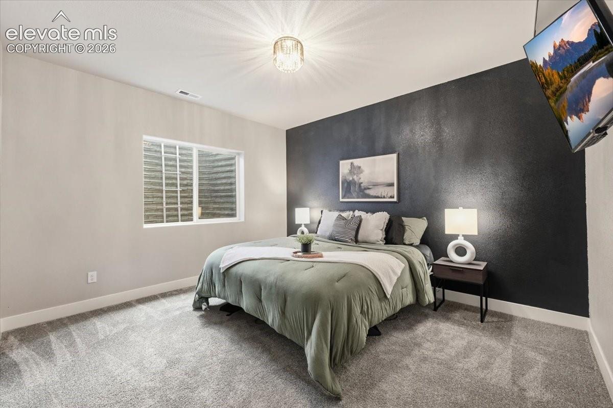 Wall-mounted television, recessed window, wall-to-wall carpeting, and overhead lighting fixture
