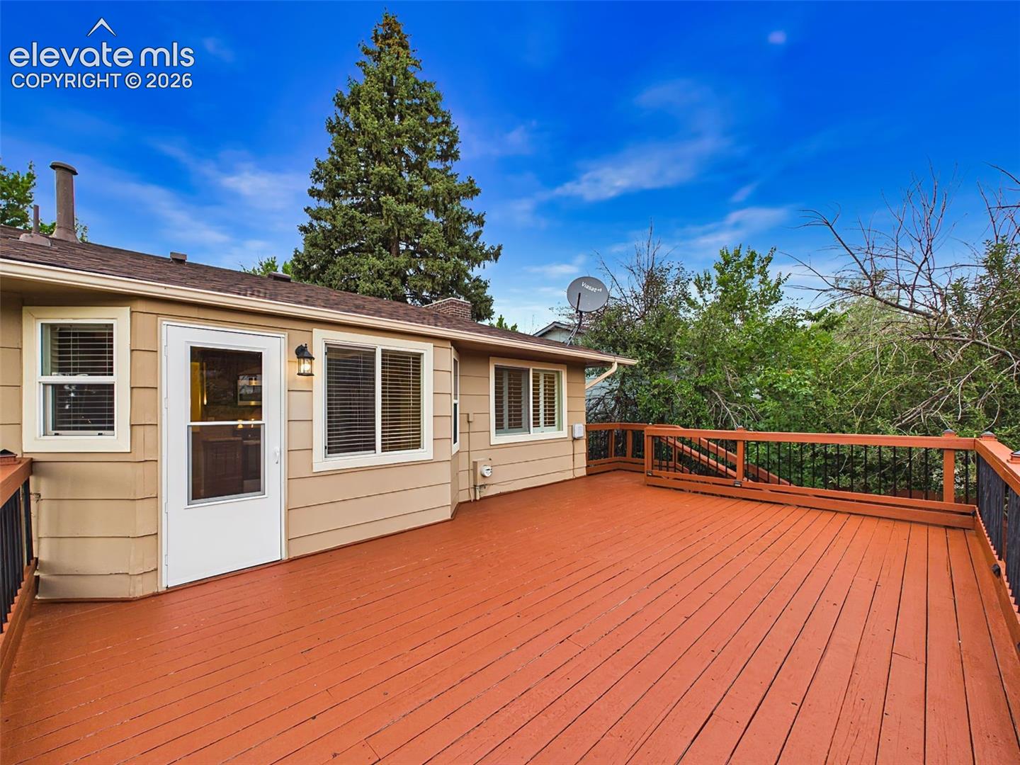 Alternate view highlights the deck’s generous size, direct access from the home, and private outdoor setting.