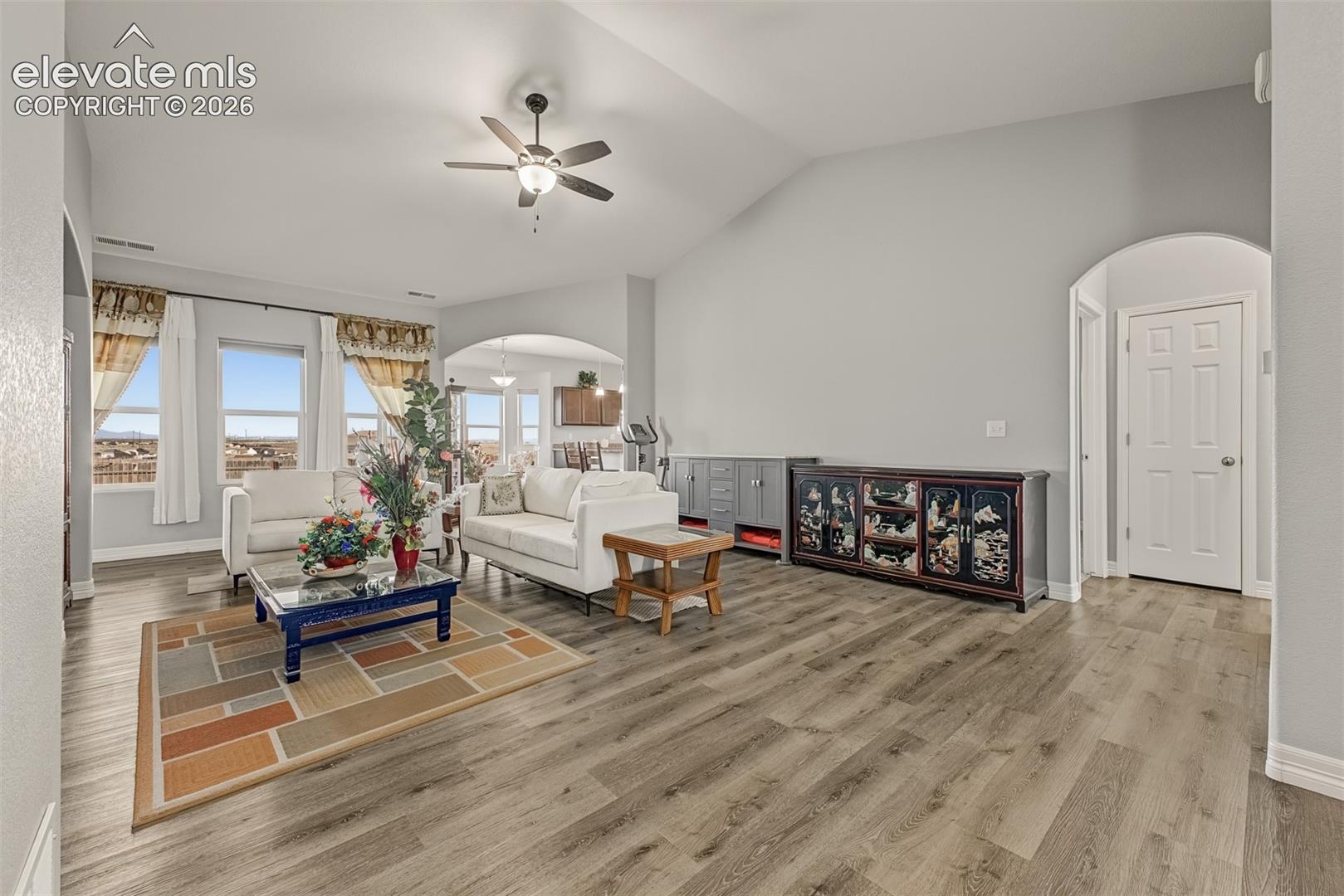 Open floor plan with vaulted ceilings and arched doorways allow for easy entertaining. 