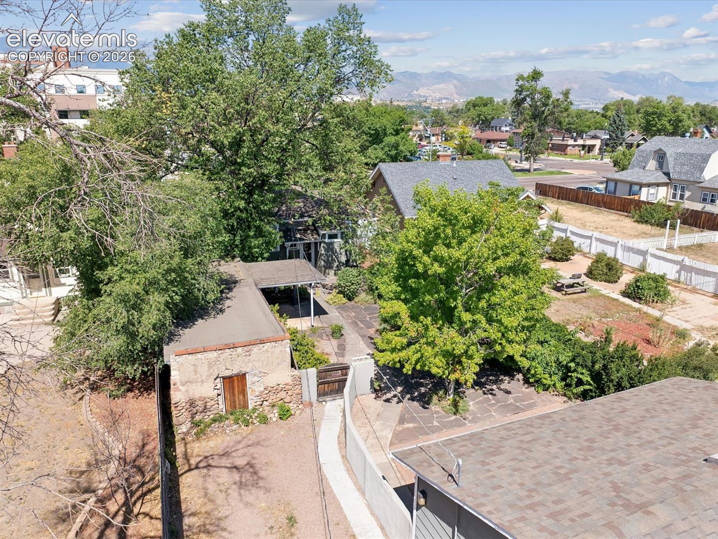 Aerial perspective showcasing a multi-level property with mature trees