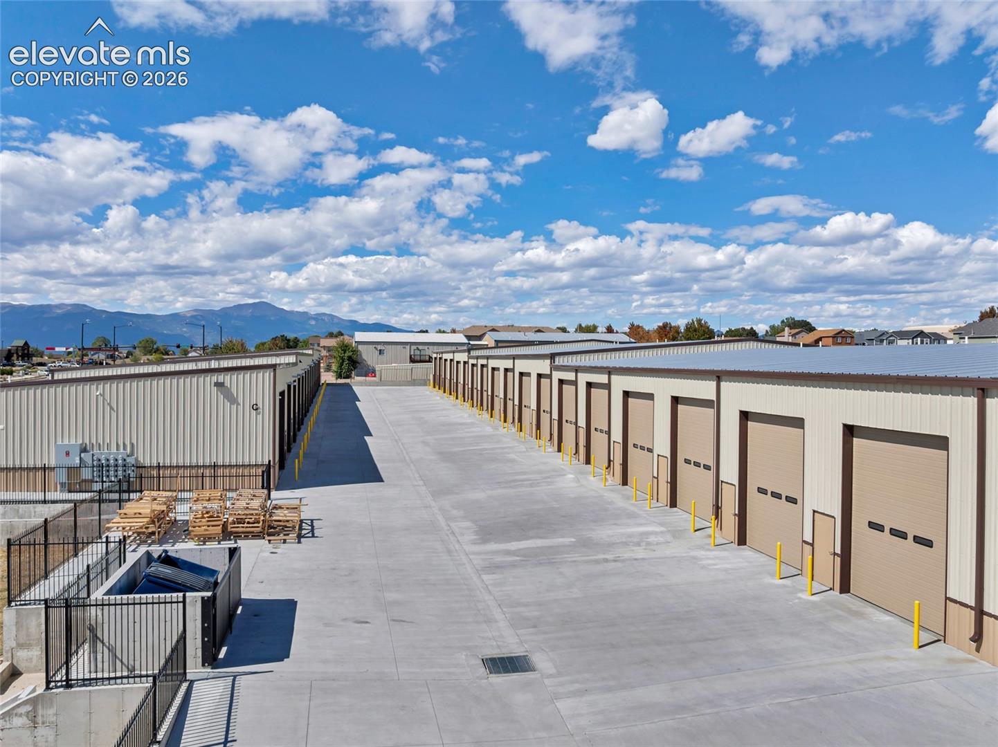 Expansive concrete driveways with multiple storage units featuring roll-up doors