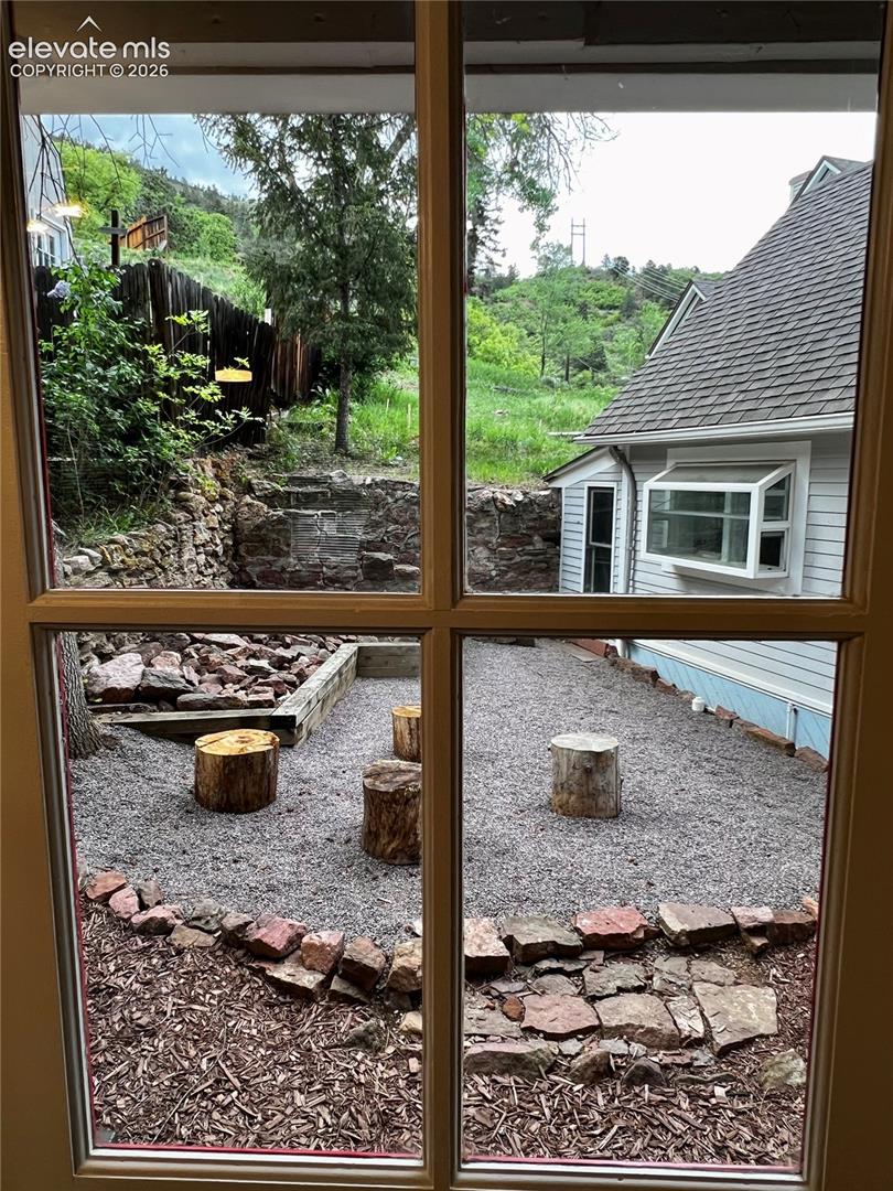 Upper Apt: View from kitchen to the patio with fire pit and picnic table