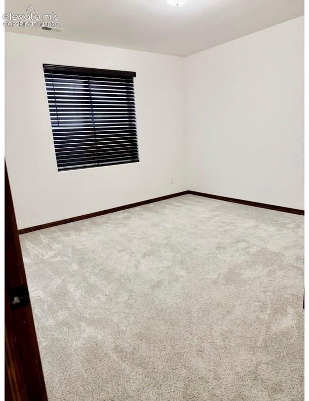 Spacious room with light-toned carpeting and white walls