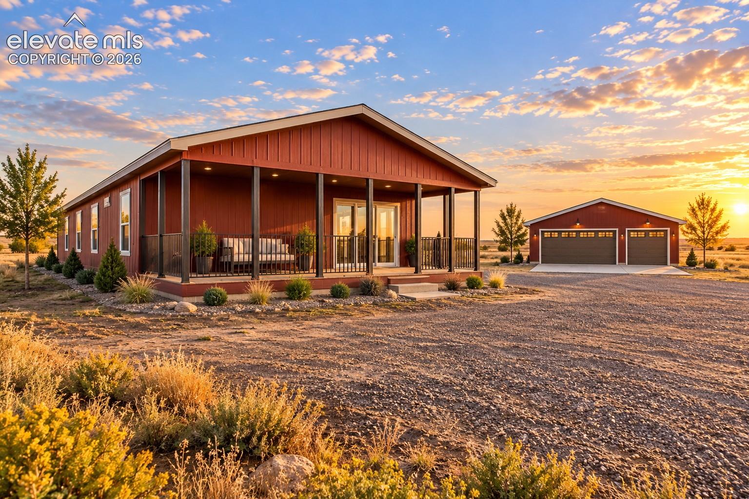 Exterior – Angled exterior view emphasizes the expansive covered porch and detached garage, with established landscaping framing the home against an open backdrop.