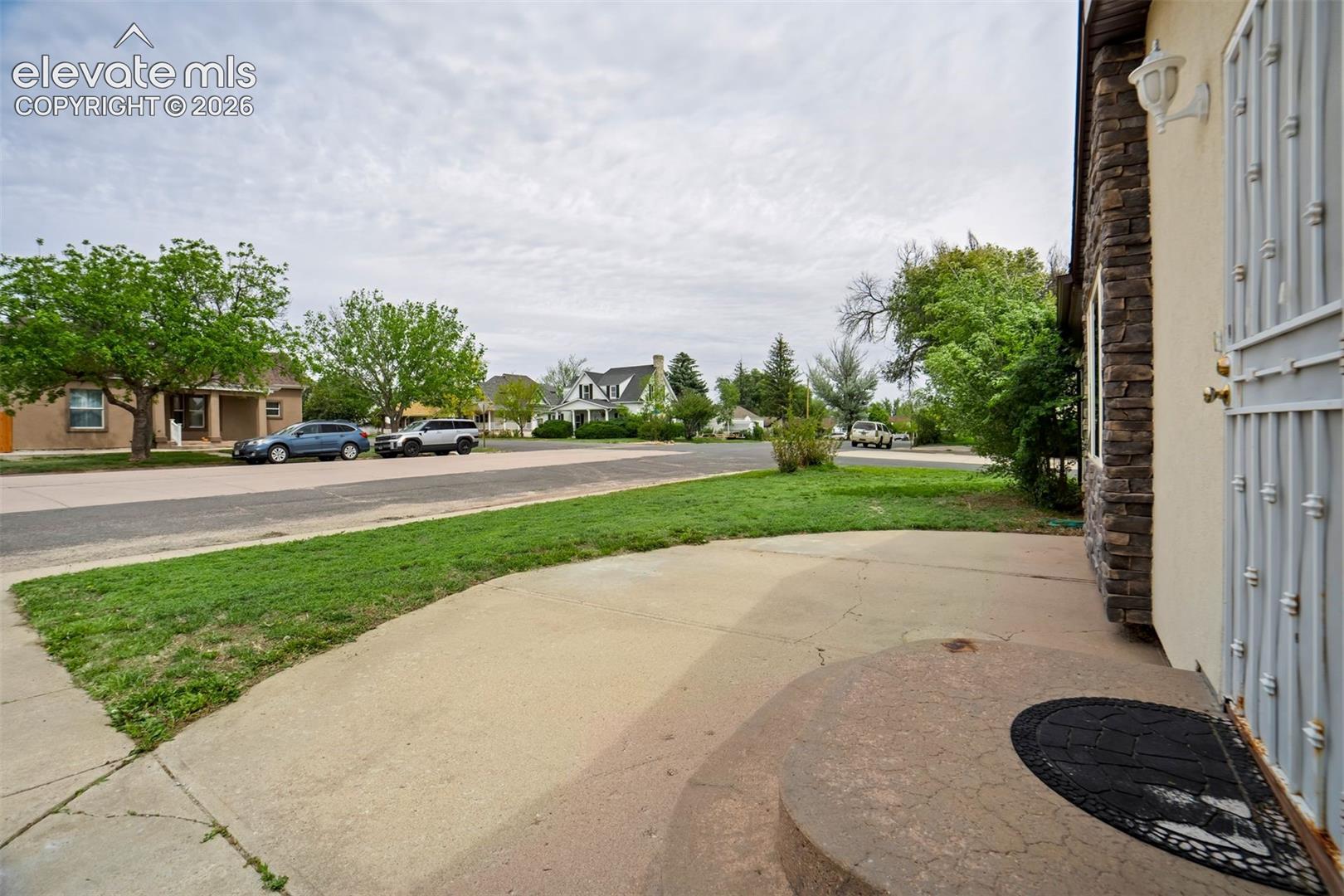 Curved front patio creates an inviting outdoor entry space.
