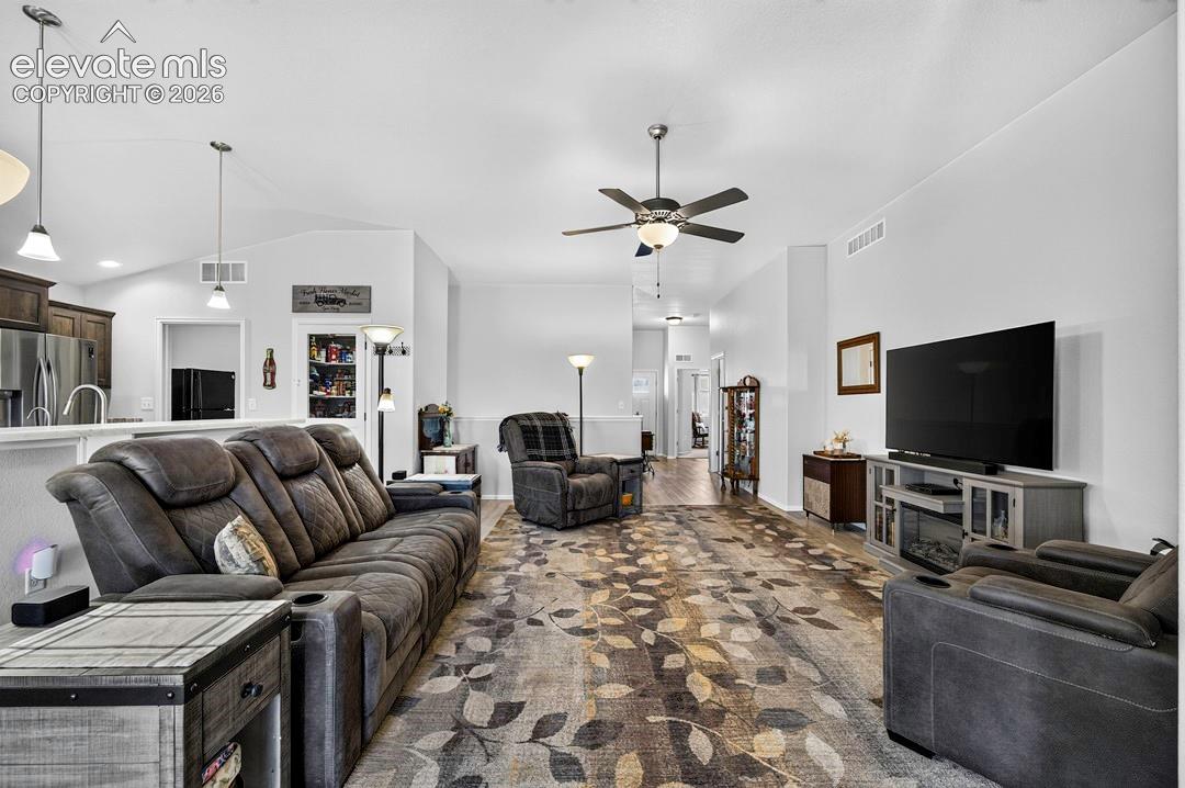 Open-concept living space featuring vaulted ceilings, a ceiling fan with integrated lighting, and recessed lighting