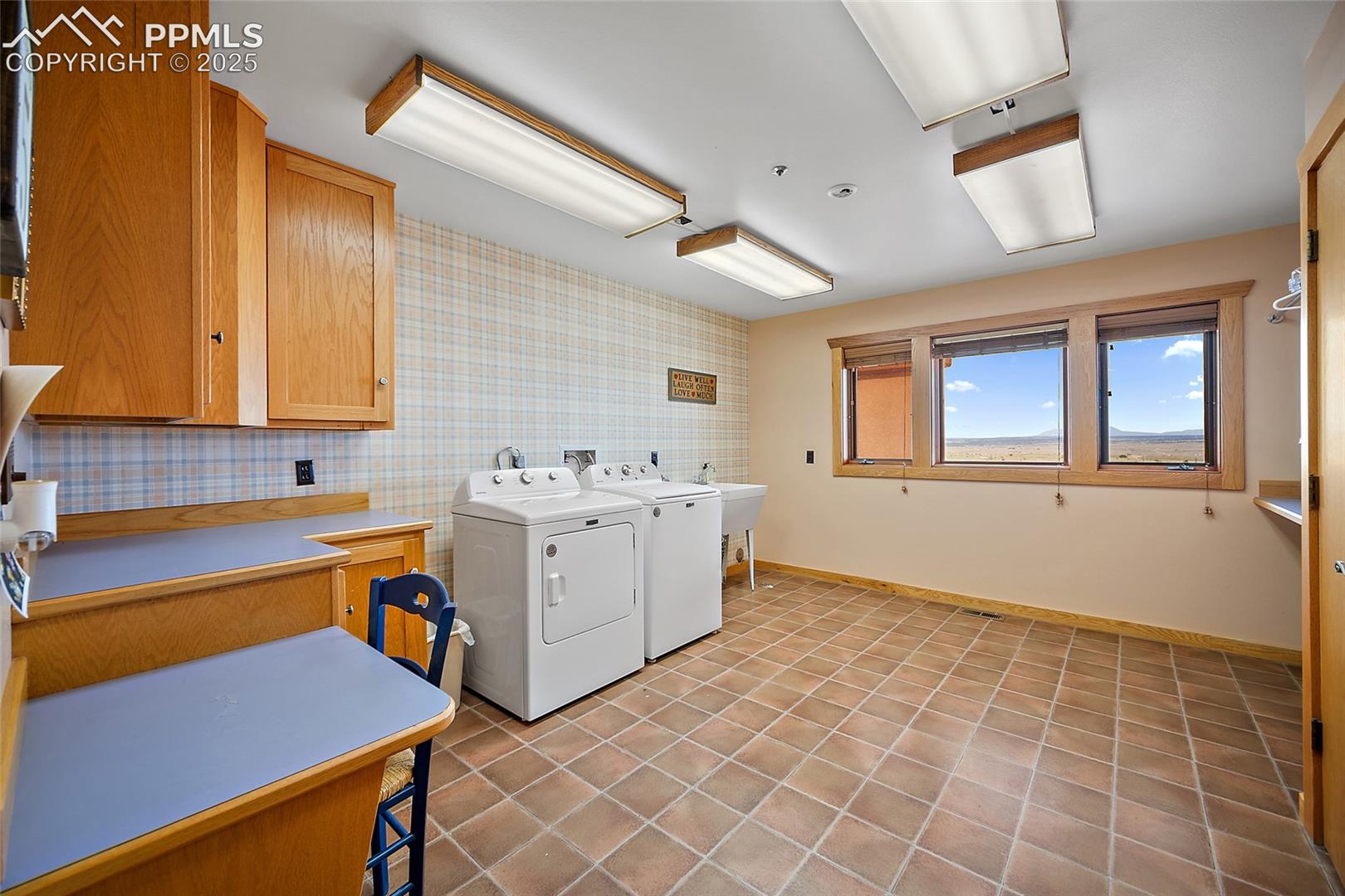 Laundry room featuring light tile patterned floors and washing machine and clothes dryer