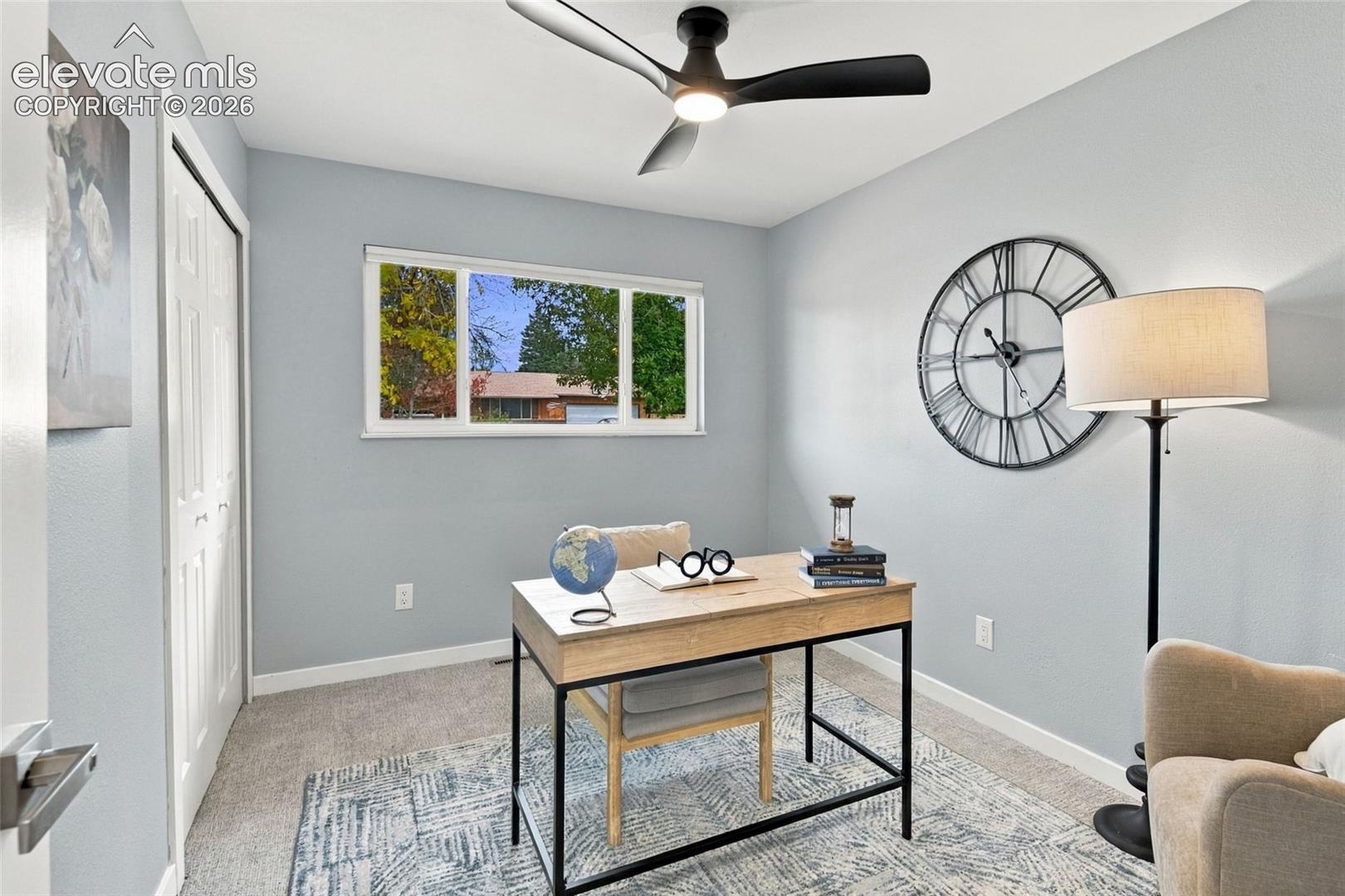 Interior space featuring neutral-toned carpeting, a horizontal sliding window, and a matte black integrated ceiling fan with light fixture
