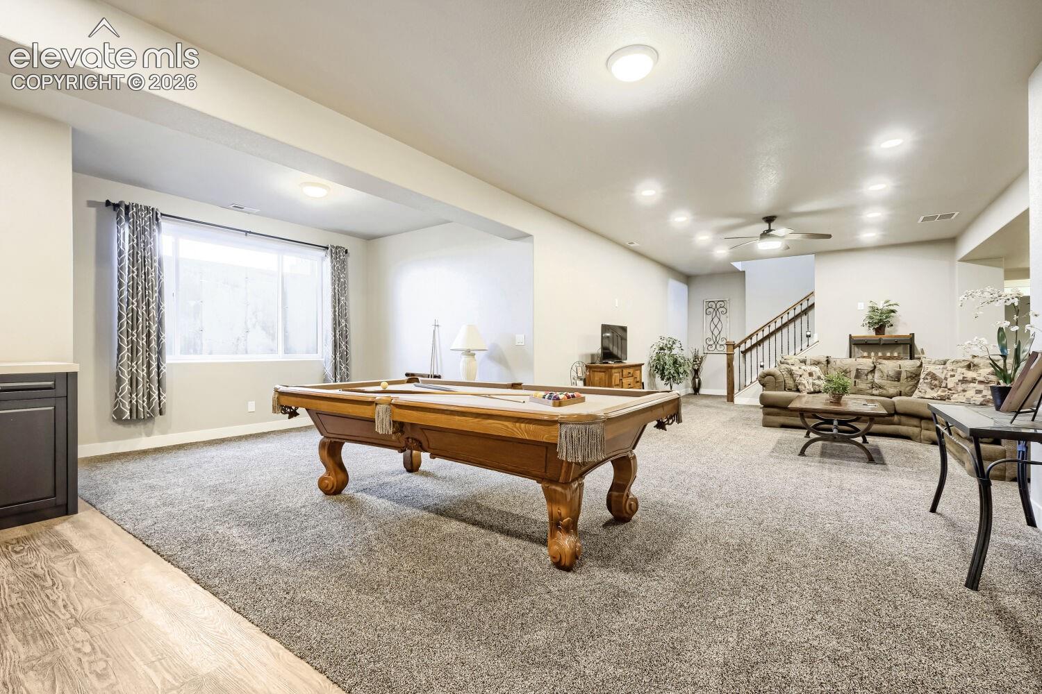 Spacious interior with plush carpeting, recessed lighting, and a ceiling fan