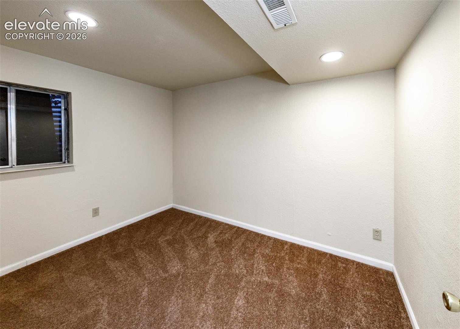 Neutral wall color, carpeted flooring, and recessed lighting