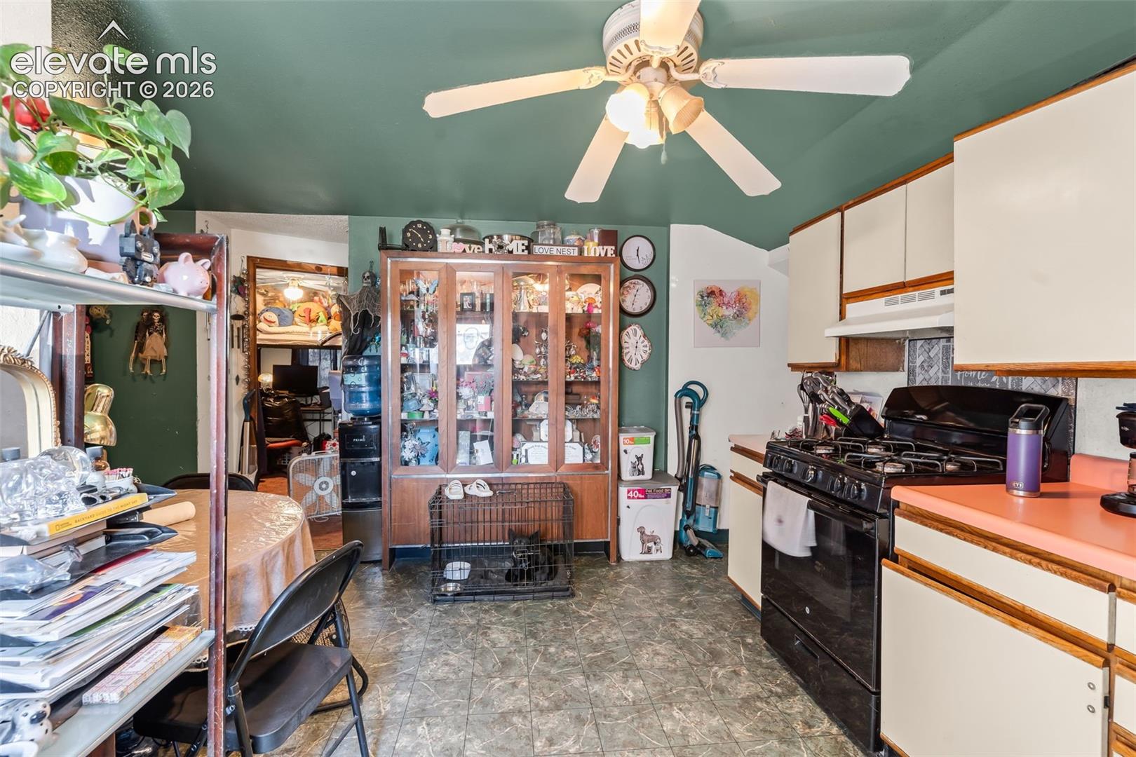 Kitchen with a ceiling fan, white upper and lower cabinetry, a black gas range, and a peach-toned countertop