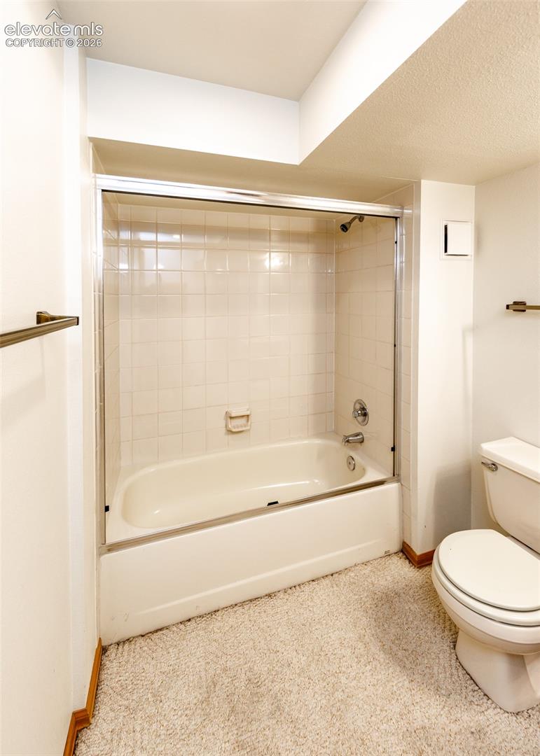 Tub and shower combination with glass enclosure and tiled surround