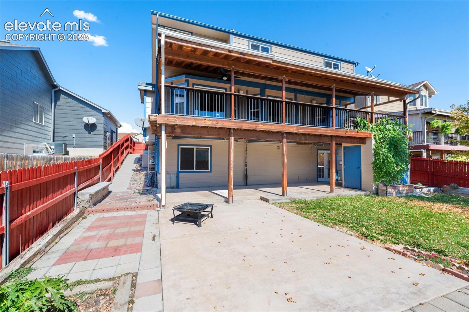 Two-story structure with a covered balcony, wood railing, and exposed wood support beams