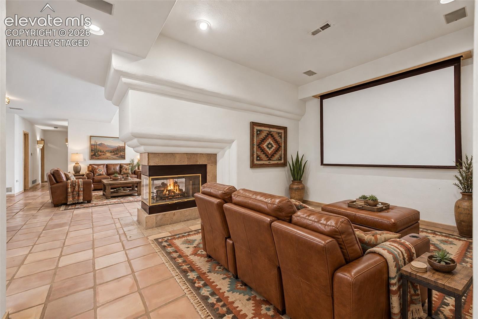 Virtually Staged
Recessed lighting, a built-in media screen, and a two-sided fireplace with a stone surround