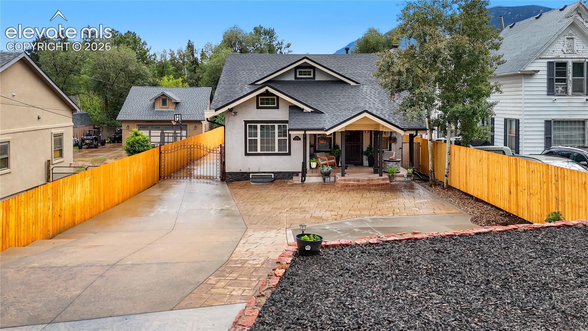Charming Craftsman-style home featuring a spacious backyard with professionally finished hardscape patio, gravel landscaping, and mature tree coverage