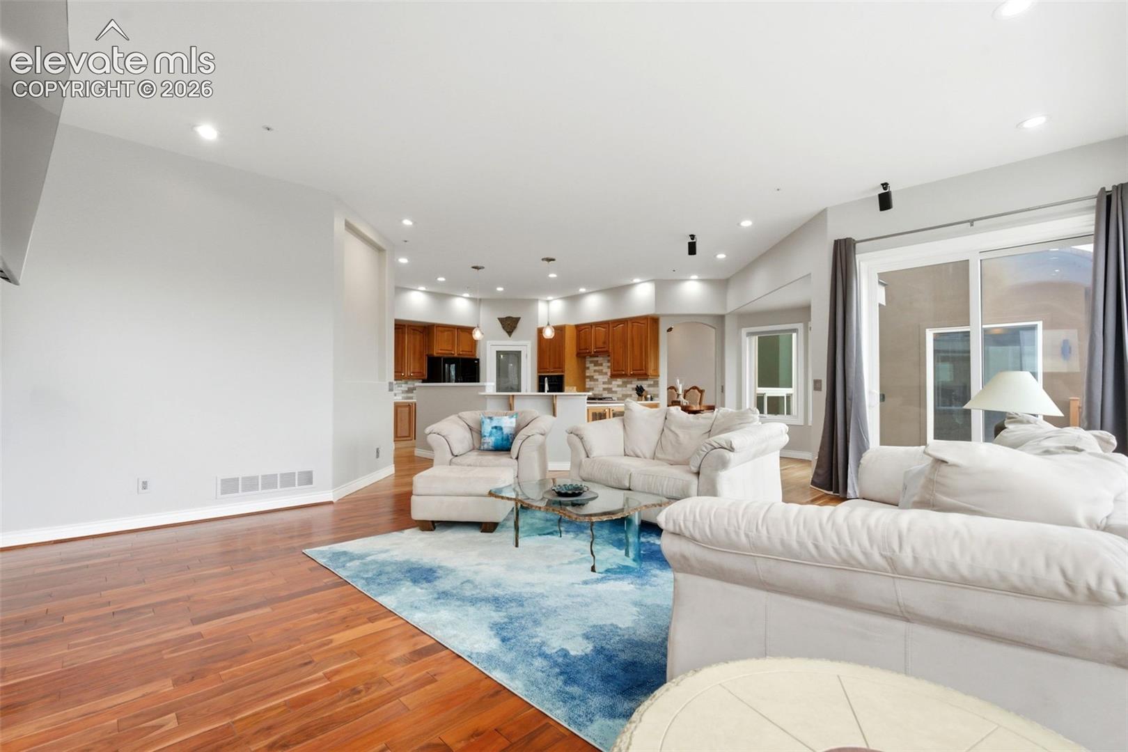 Hardwood flooring, recessed lighting, and a sliding glass door