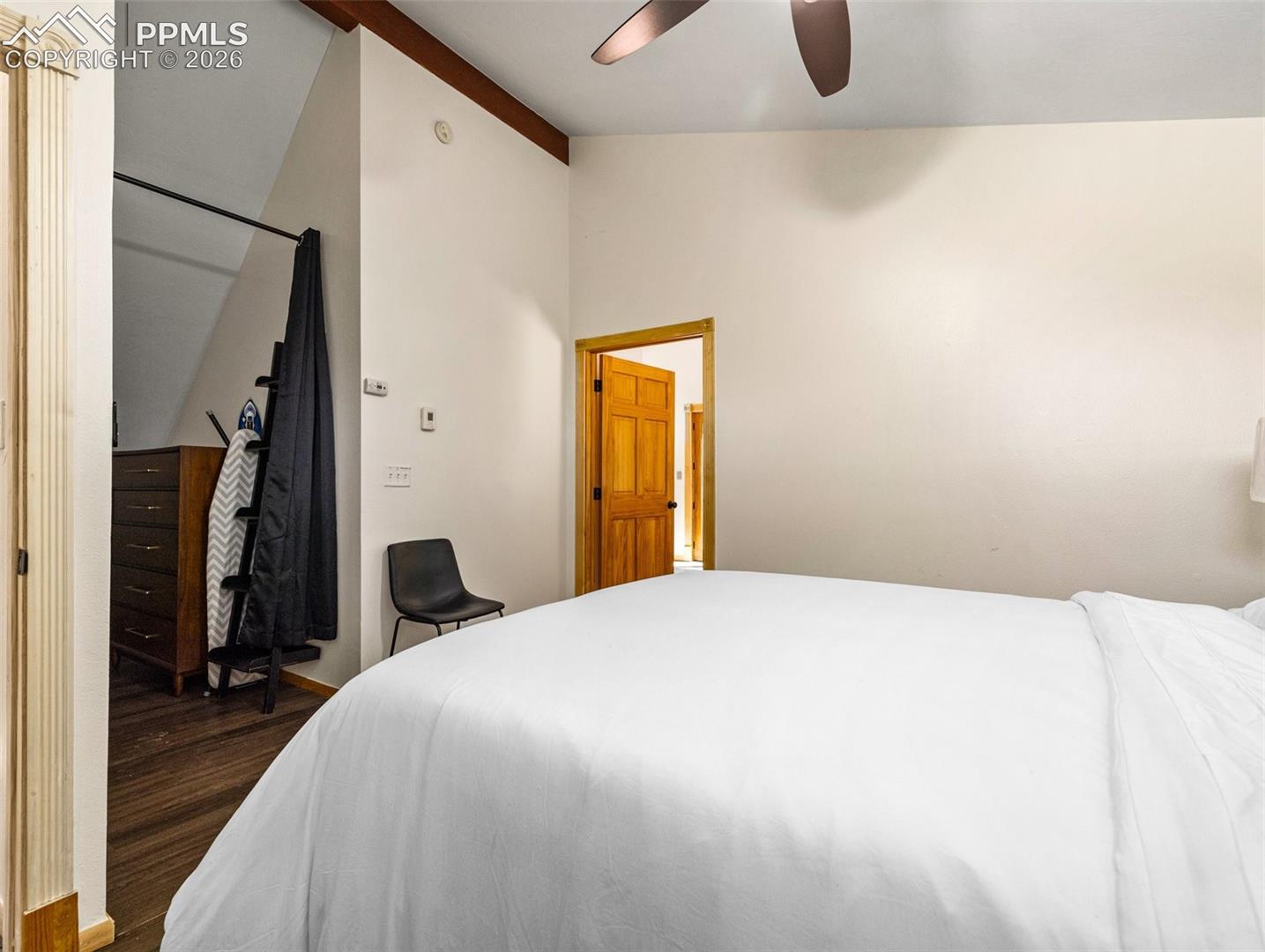 Bedroom featuring vaulted ceiling, a ceiling fan, and dark wood-type flooring