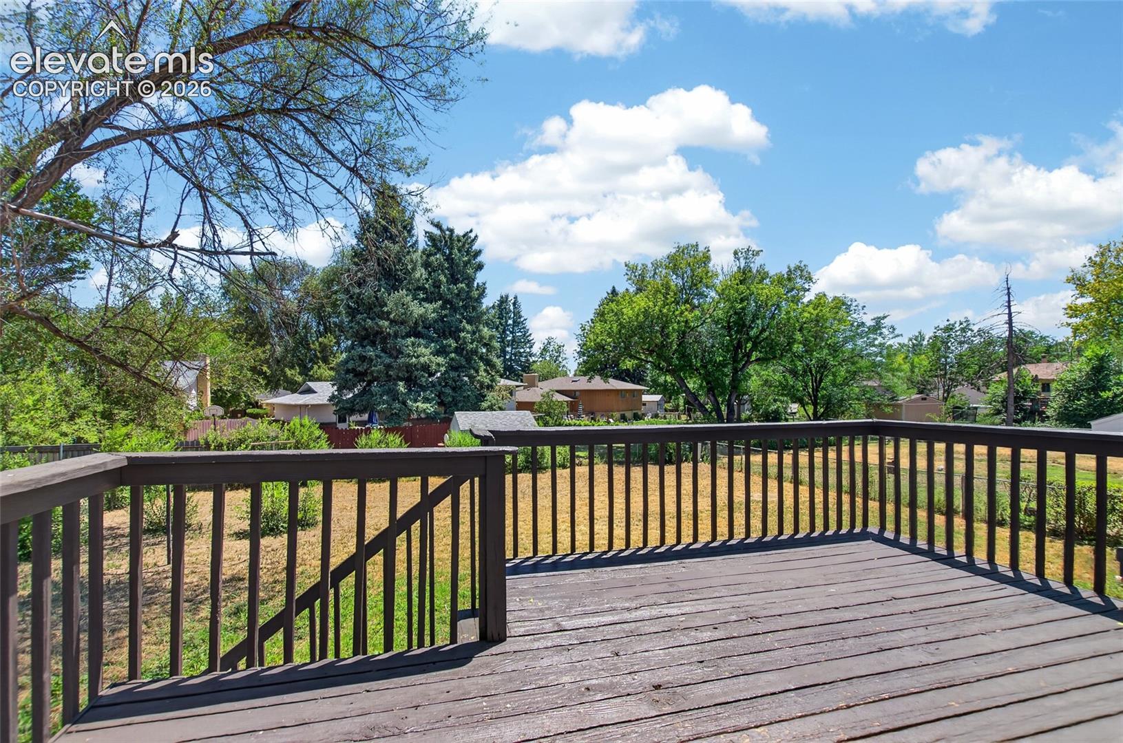 Elevated outdoor deck with wood-finish flooring and full railing