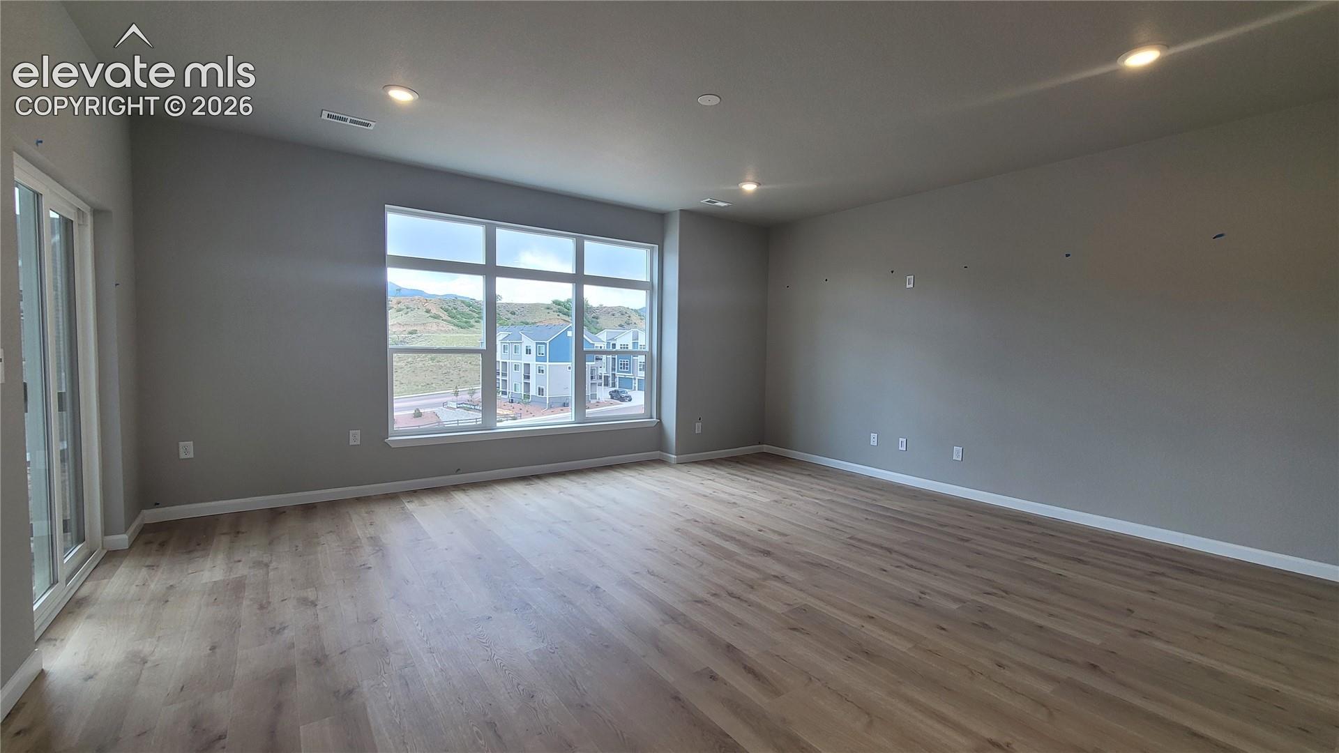 Living Room with LVP flooring, LED lighting, pre-wired for future fan, abundance of natural light, and walks out to a composite deck! 
