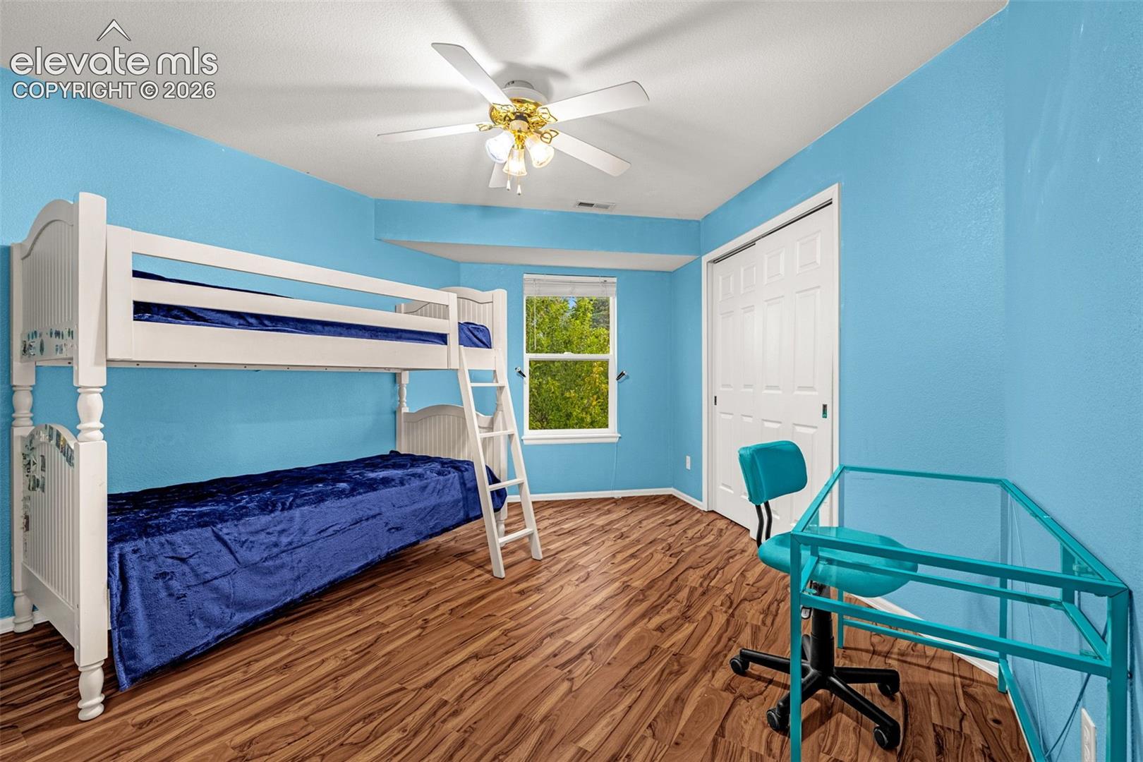 Recessed window, wood-finish flooring, ceiling fan, and white bi-fold closet doors