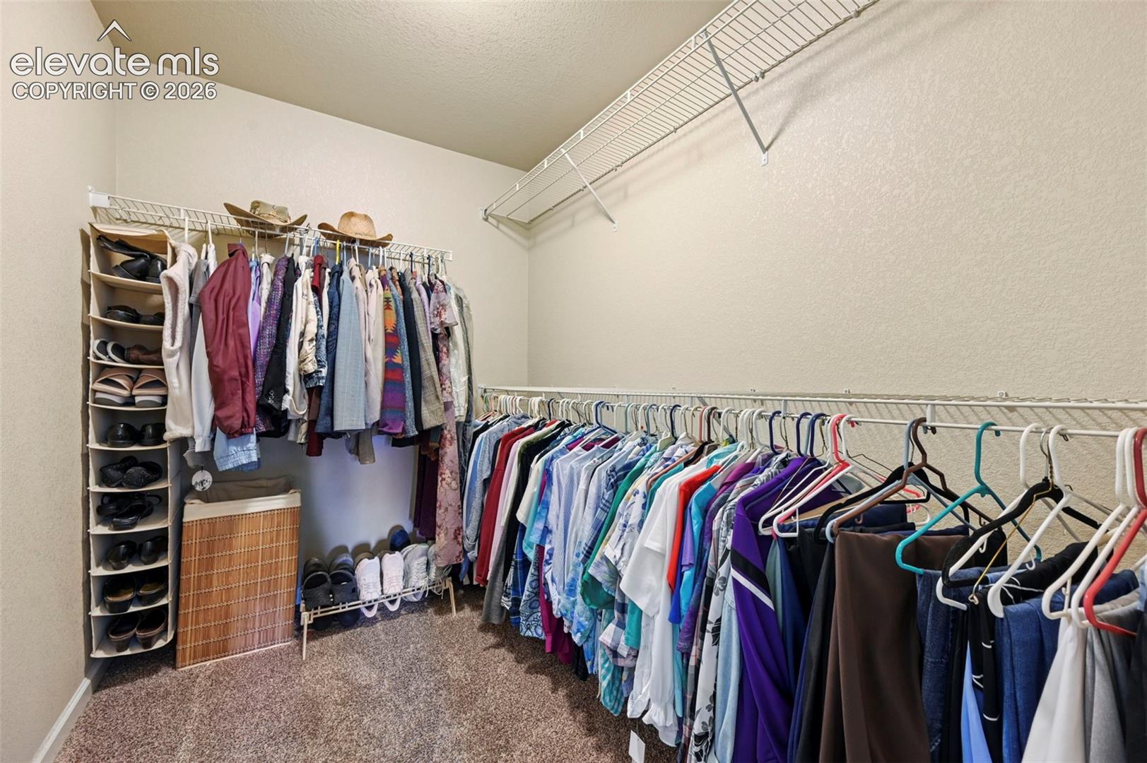 Walk in closet with wire shelving and hanging rods