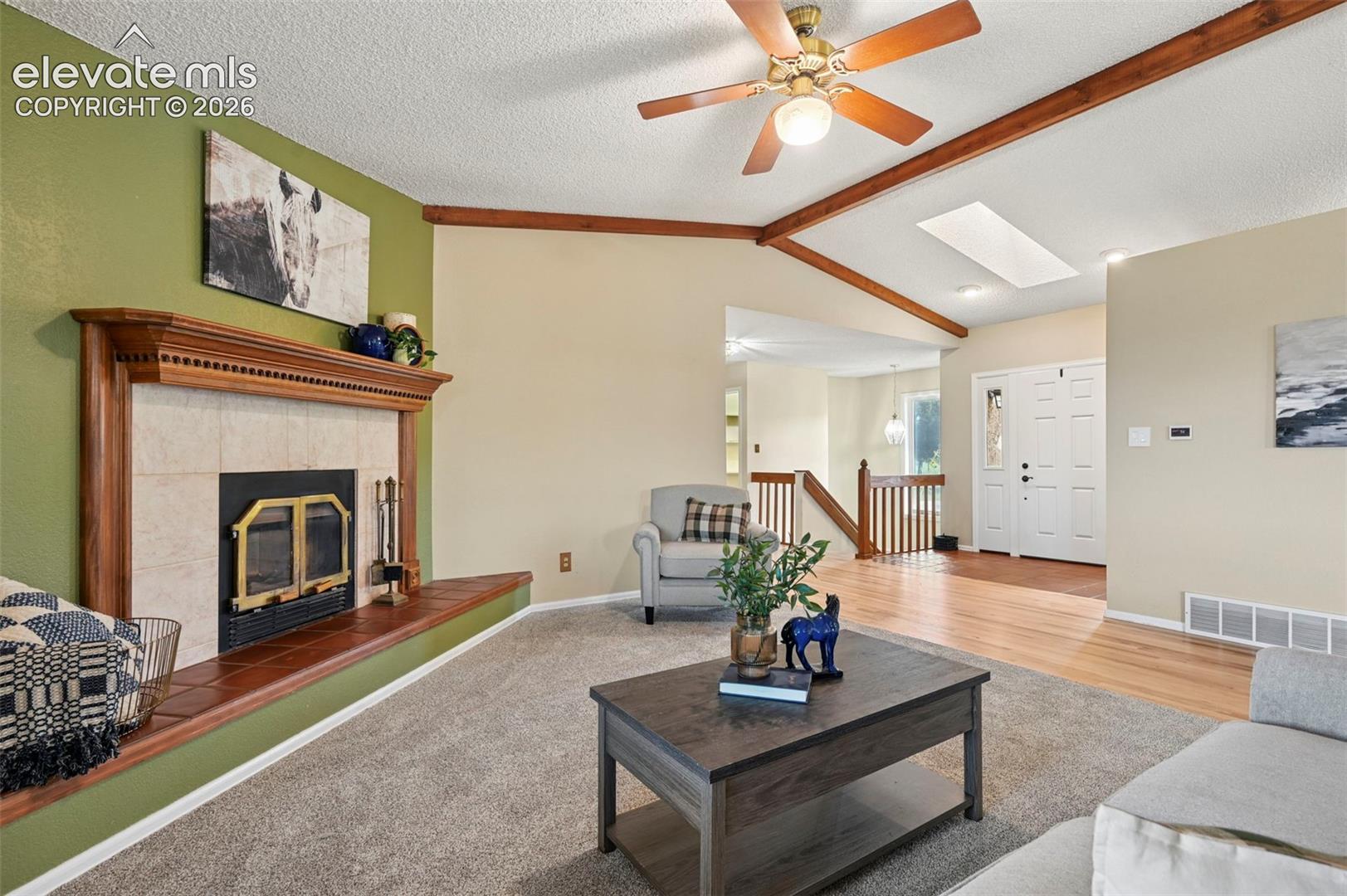 Living area with new carpet, natural hardwood flooring