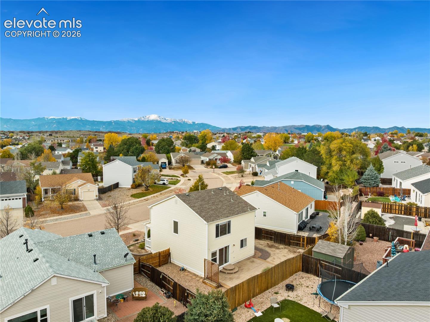 Aerial perspective featuring suburban residential surroundings with a prominent snow-capped mountain range backdrop