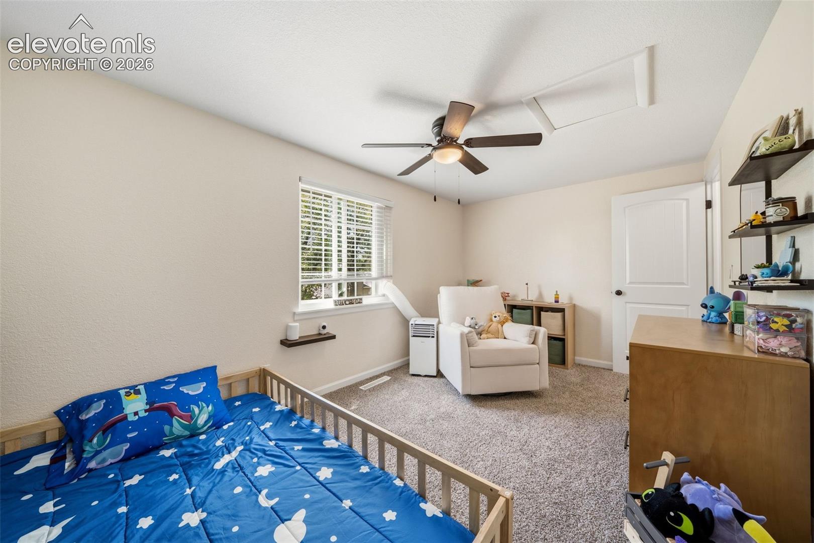 Carpeted room featuring a ceiling fan with integrated lighting, a window with blinds, and light-toned walls