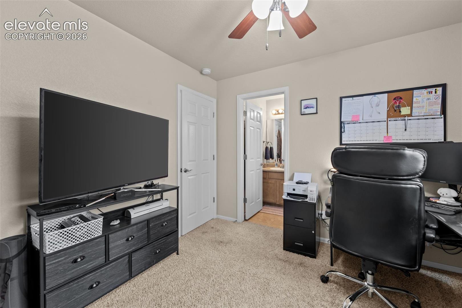 Carpeted flooring, ceiling fan with light fixture, and a white paneled door