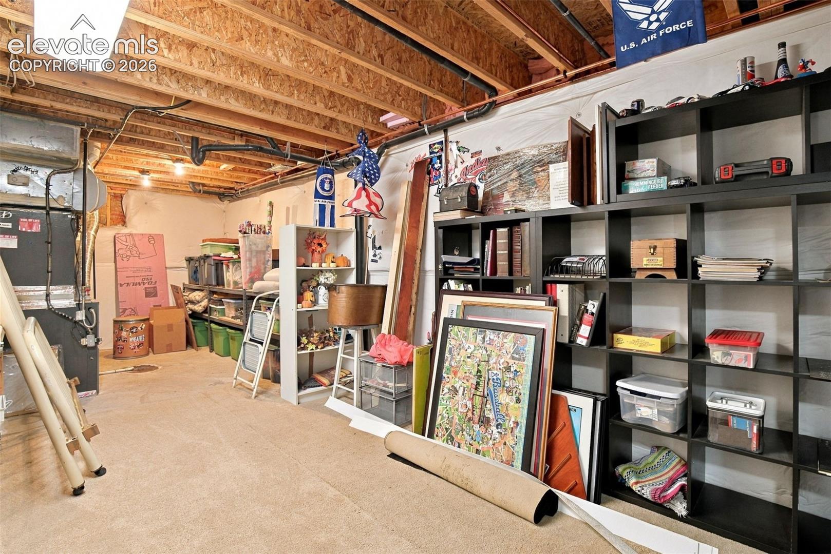 Huge unfinished utility space featuring exposed wooden floor joists, concrete flooring, and an integrated furnace system